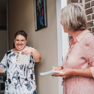 Een opbouwwerker gaat langs bij een buurtbewoner.