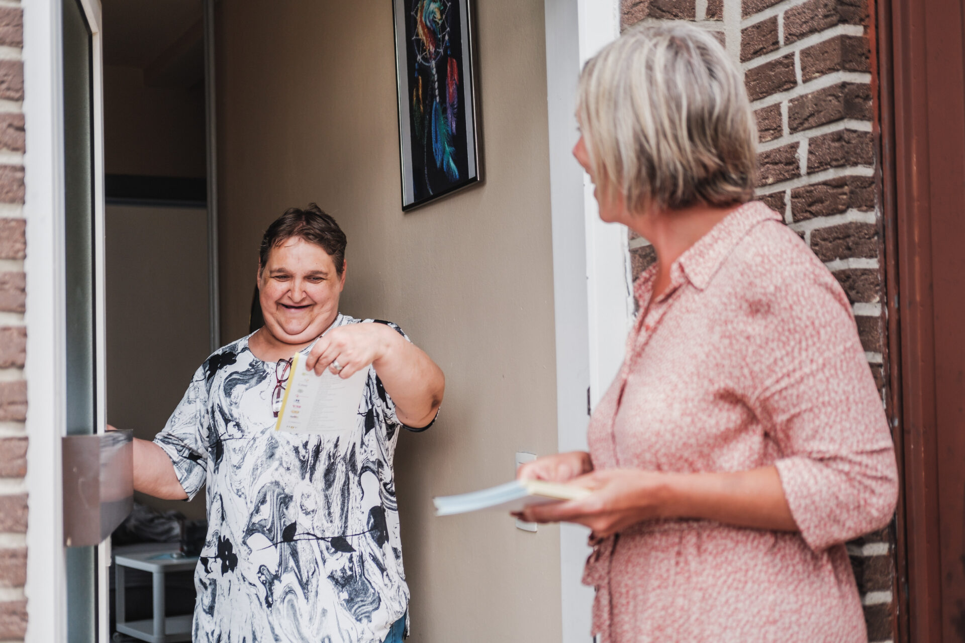 Een opbouwwerker gaat langs bij een buurtbewoner.