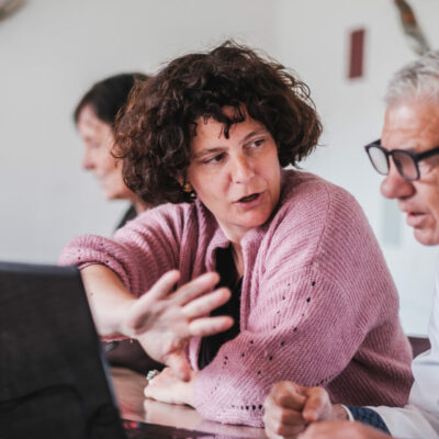 Opbouwwerker Tineke geeft uitleg aan de computer.
