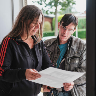 Opbouwwerker en buurtbewoner bekijken een document.
