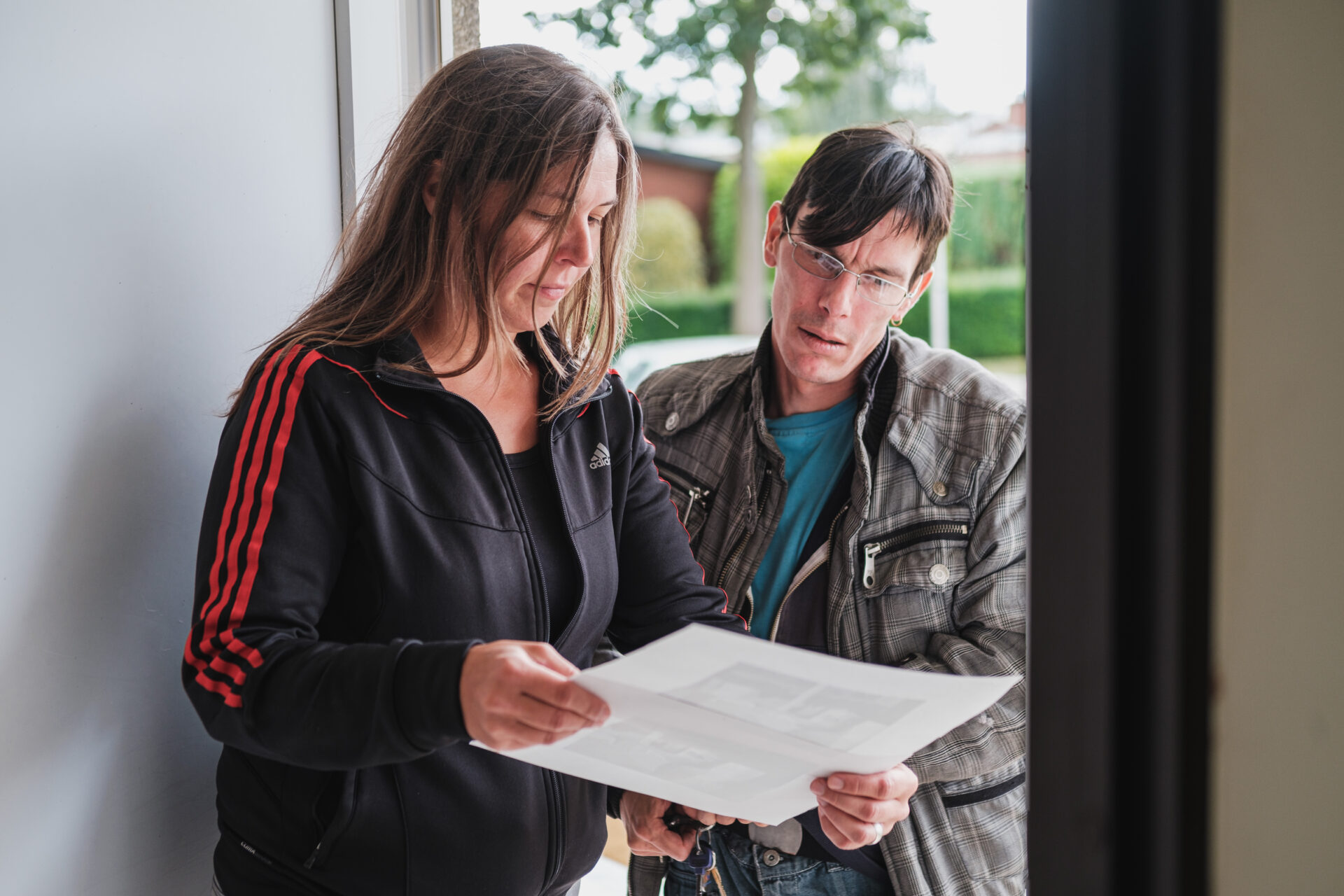 Opbouwwerker en buurtbewoner bekijken een document.
