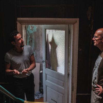 Opbouwwerker en bewoner bij woning die aan renovatie toe is.