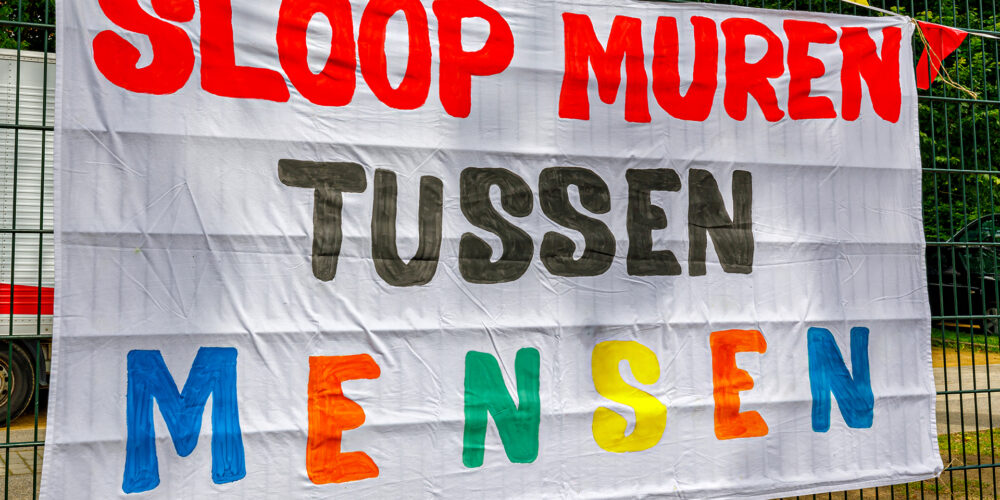 Banner over muren tussen mensen slopen tijdens Langste Tafel in Zaventem