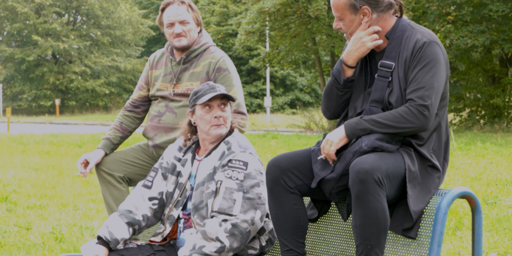 Kurt, Emmanuel en Vincent zitten op een bankje in het park