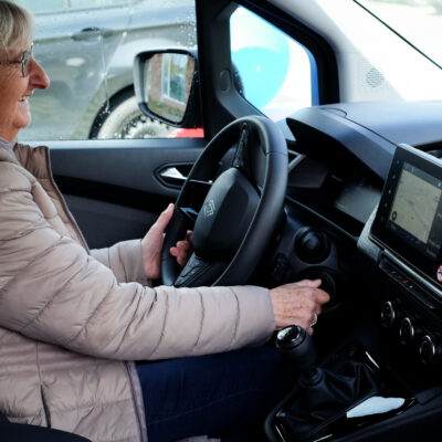 Vrouw achter stuur van deelwagen